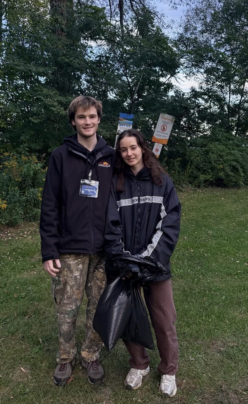 Two volunteers with a collection bag at a neighbourhood cleanup